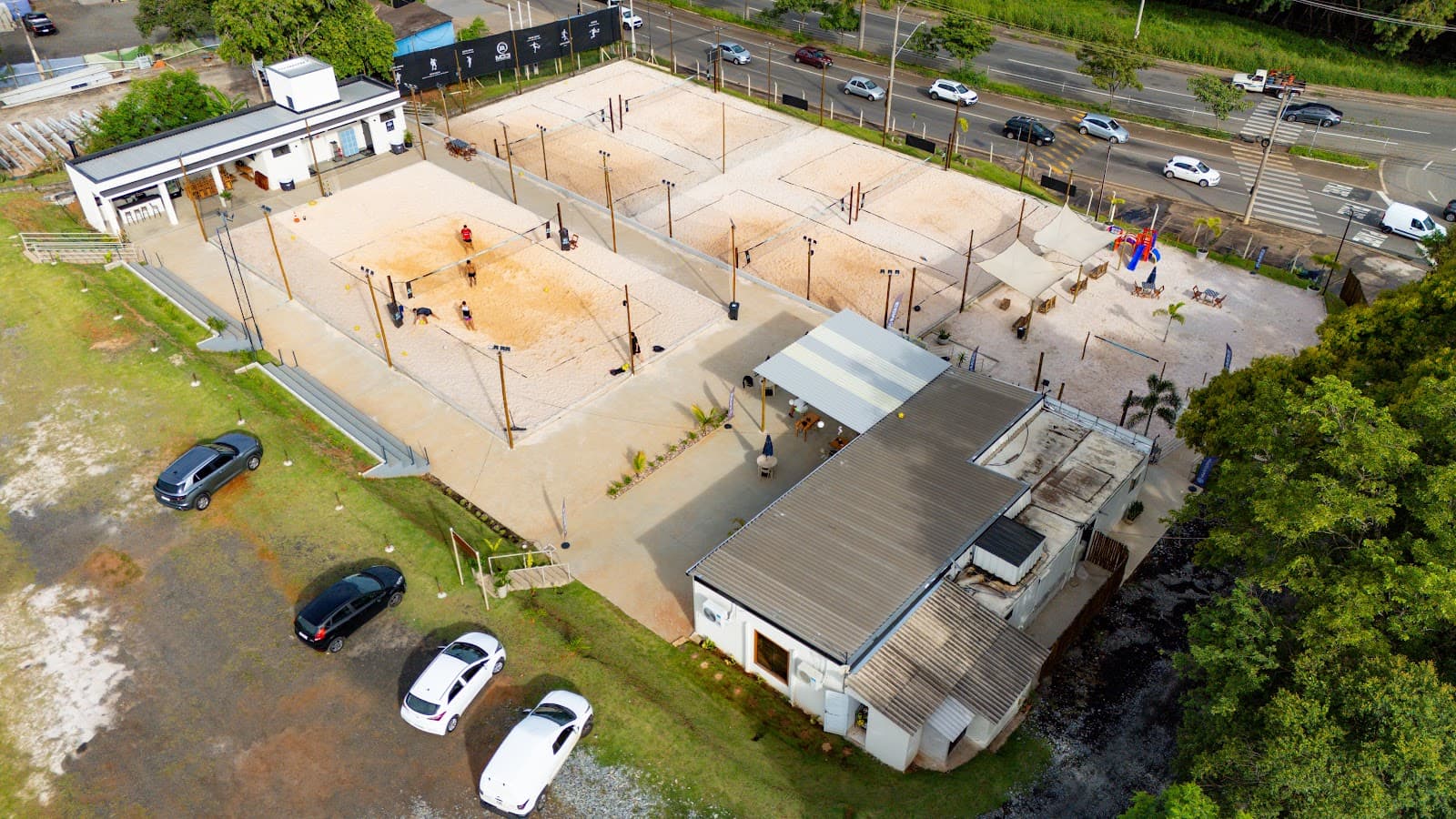 Vista aérea das quadras de areia da Arena M33, com jogadores numa delas
